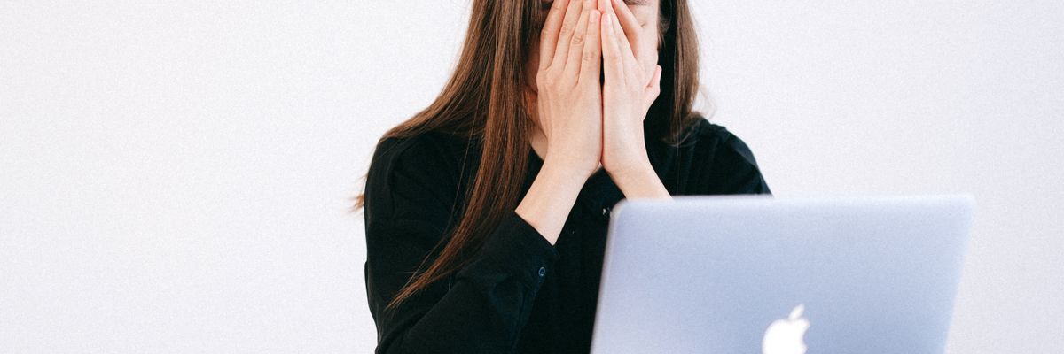 職場でストレスが限界になり顔を覆う女性会社員