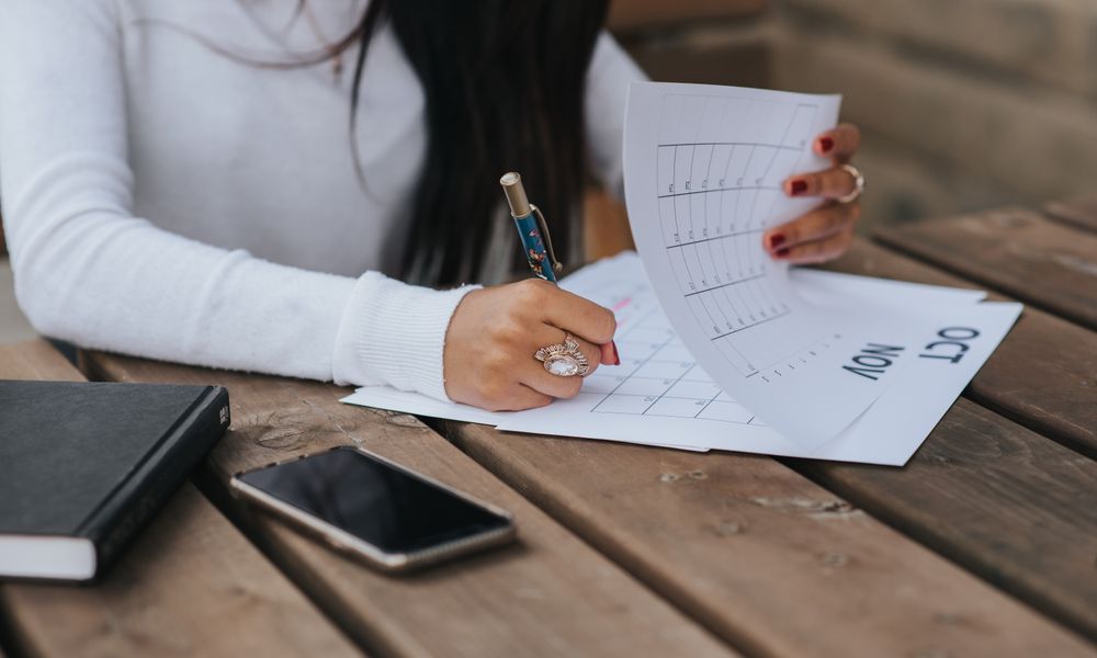 予定にバッファを持たせて手帳でスケジュールを整える女性