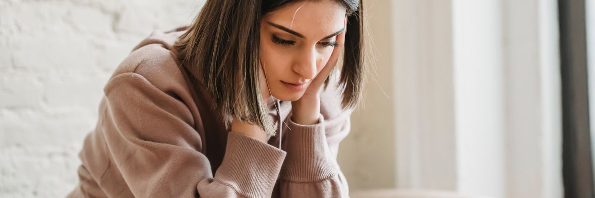 ストレスで涙が出そうになりうつむく女性